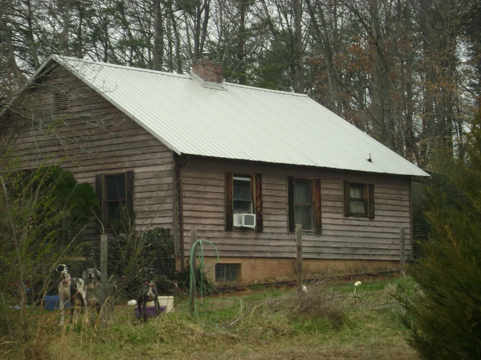 White metal roof on an old wood sided farmhouse, from a Metal Roof Installation job in Waco